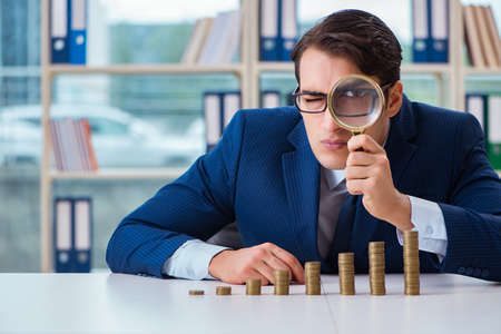 Businessman with stacks of coins in the officeの写真素材