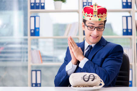 King businessman with money sack in officeの写真素材