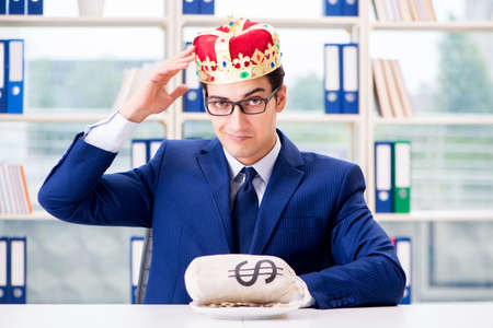 King businessman with money sack in officeの写真素材
