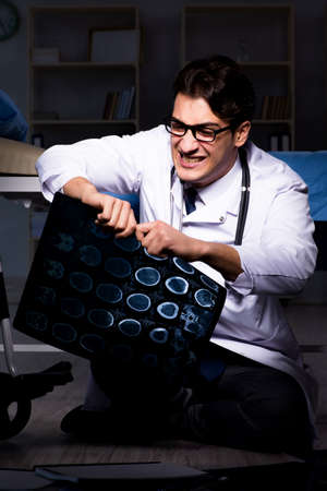 Doctor working night shift in hospital after long hoursの写真素材