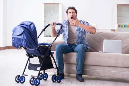 Young father looking after newborn baby at homeの写真素材