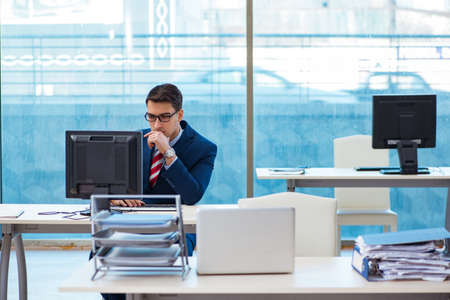 Young handsome businessman employee working in office at deskの写真素材