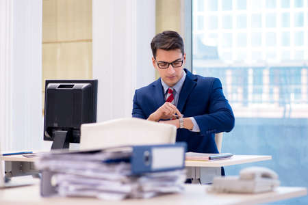 Young handsome businessman employee working in office at deskの写真素材