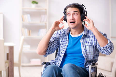 Disabled man listening to music in wheelchairの写真素材