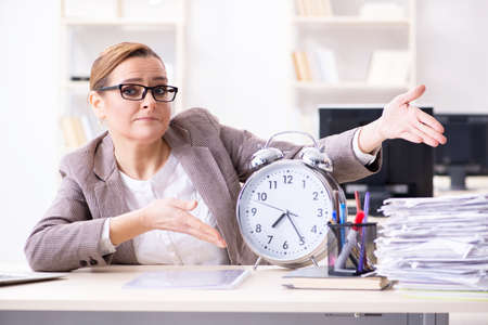 Businesswoman workaholic trying to finish urgent paperworkの写真素材