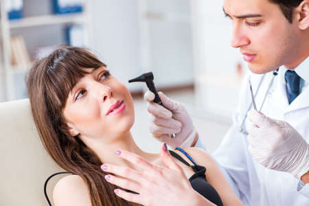 Doctor checking patients ear during medical examinationの写真素材
