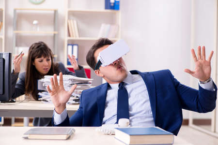 Employee with virtual reality glasses in officeの写真素材