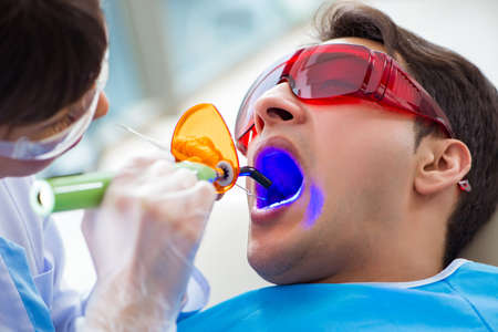 Woman dentist doctor with male patient in hospitalの写真素材