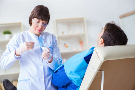 Woman dentist doctor with male patient in hospitalの写真素材