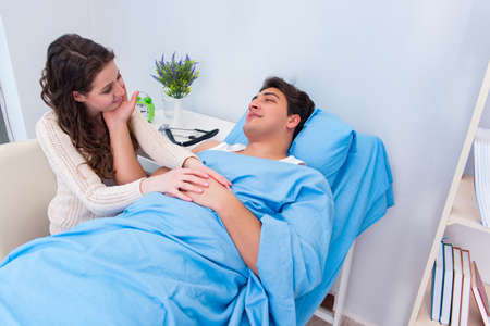 Wife visiting ill husband in the hospital roomの写真素材