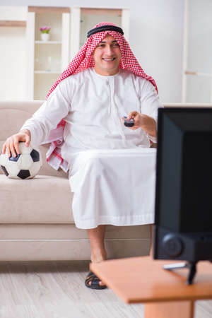 Arab businessman watching tv at homeの写真素材