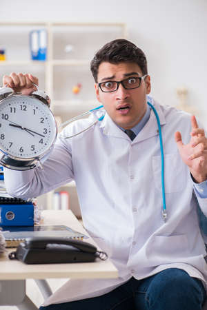 Doctor with alarm clock in urgent check-up conceptの写真素材
