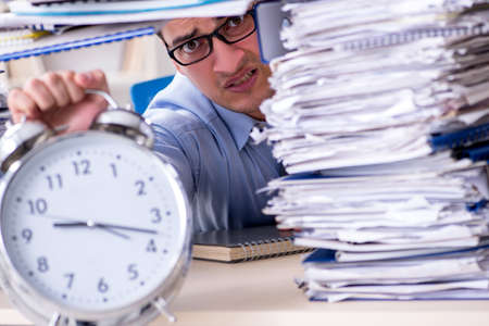 Extremely busy businessman working in officeの写真素材