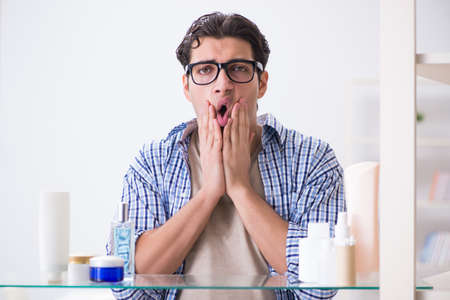 Young man is getting prepared for working day in bathroomの写真素材