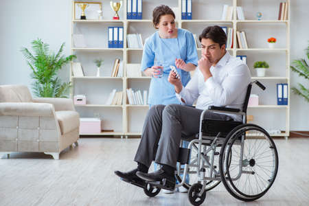 Disabled patient on wheelchair visiting doctor for regular checkの写真素材