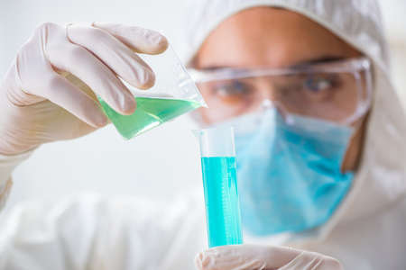 Young chemist student working in lab on chemicals