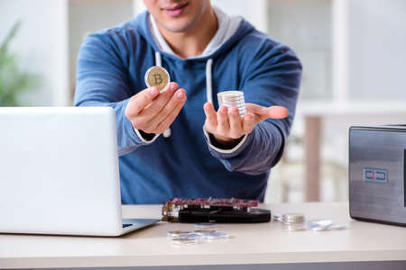 Young man mining bitcoins at home