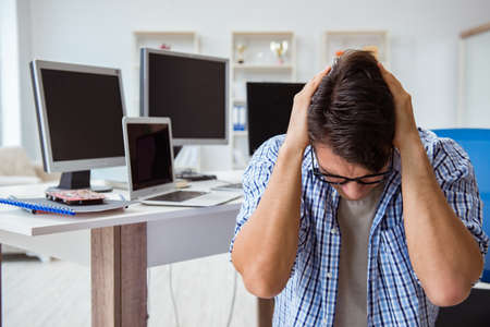 Businessman sitting in front of many screensの写真素材