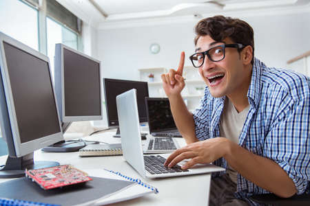 Businessman sitting in front of many screens