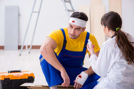 Worker with injured head and doctorの写真素材