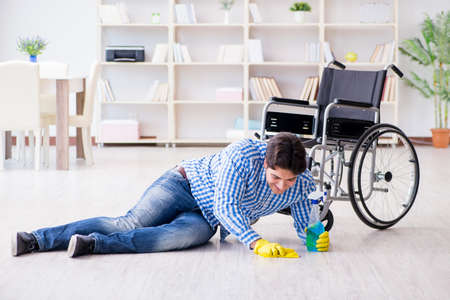 Disabled man on wheelchair cleaning homeの写真素材