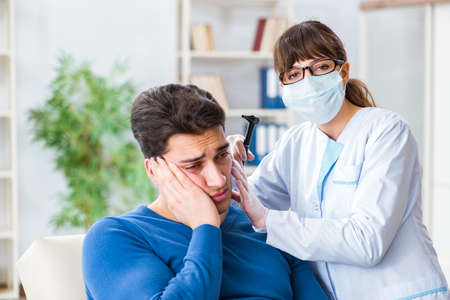 Doctor checking patients ear during medical examinationの写真素材