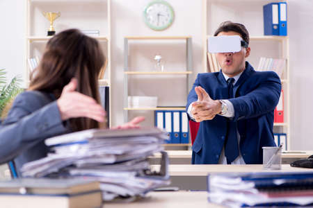 Employee with virtual reality glasses in officeの写真素材
