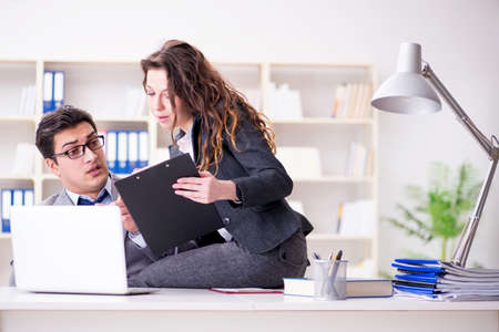 Sexual harassment concept with man and woman in officeの写真素材