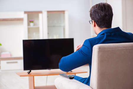 Businesman watching tv in officeの写真素材