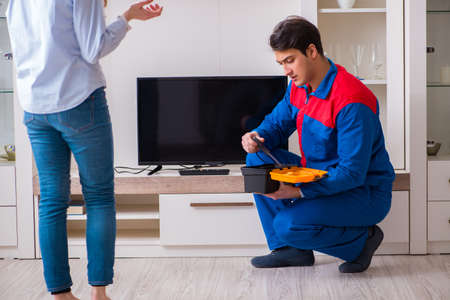 Repairman repairing tv at homeの写真素材