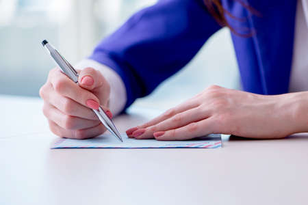 Businesswoman writing notes at desk
