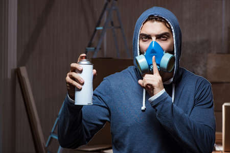 Graffiti painter in dark smokey roomの写真素材