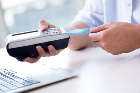 Man processing credit card transaction with POS terminal