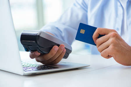 Man processing credit card transaction with POS terminalの写真素材