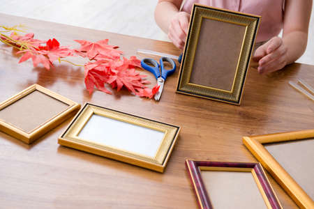 Woman decorating picture frame in scrapbooking conceptの写真素材