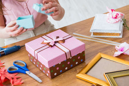 Woman decorating gift box for special occasionの写真素材