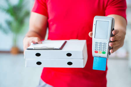 Pizza delivery being paid with pos and credit cardの写真素材