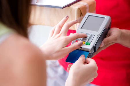 Parcel delivery being paid with pos and credit cardの写真素材
