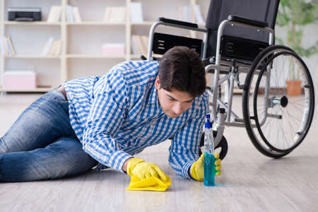 Disabled man on wheelchair cleaning homeの写真素材