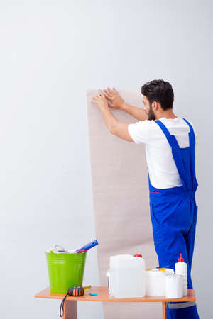 Worker working on wallpaper during refurbishment