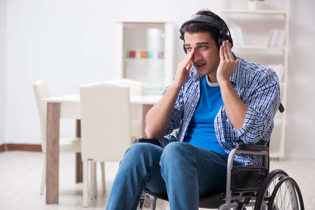 Disabled man listening to music in wheelchairの写真素材
