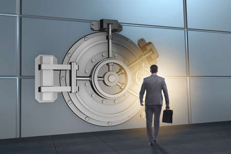 Businessman in front of banking vault doorの写真素材