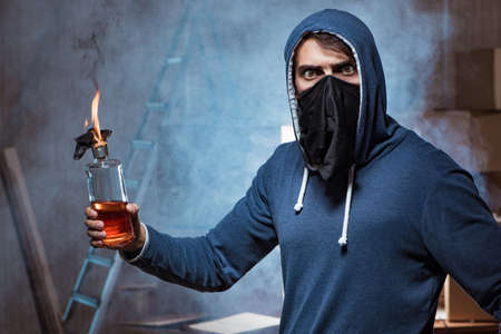 Rebel with molotov cocktail in dark roomの写真素材