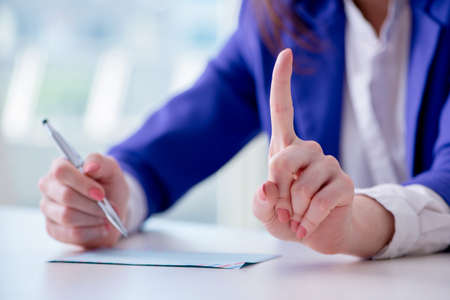 Businesswoman writing notes at desk