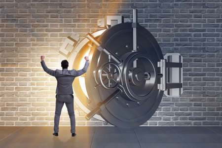 Businessman in front of banking vault doorの写真素材