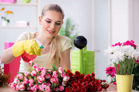 Young woman watering plants in her gardenの写真素材