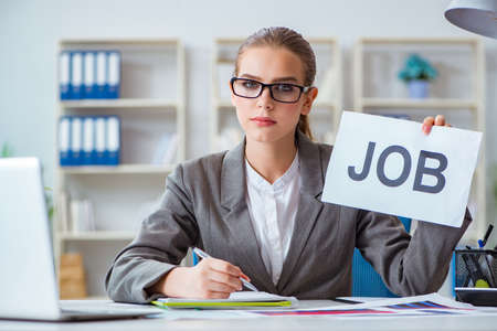 Businesswoman sitting in office with messageの写真素材