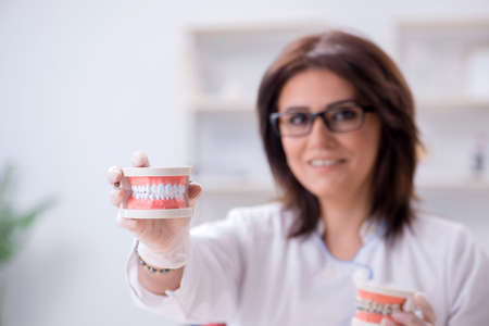 Woman dentist working on teeth implant