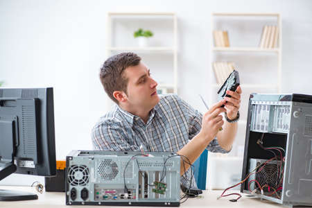 Young technician repairing computer in workshop