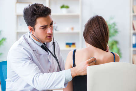 Doctor checking patient with stethoscopeの写真素材